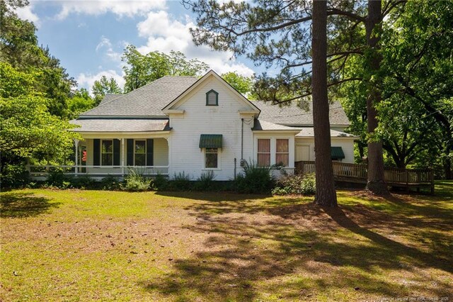 5648 Tolarsville Rd, Saint Pauls, NC 28384 - view of front facade featuring a front lawn, a shingled roof, and a wooden deck