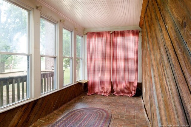 5648 Tolarsville Rd, Saint Pauls, NC 28384 - unfurnished sunroom featuring crown molding, brick patterned flooring, and plenty of natural light