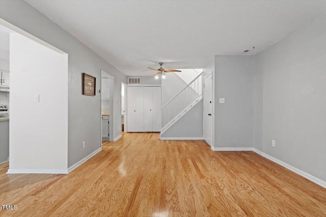 4705 Walden Pond Dr Unit 110-C, Raleigh, NC 27604 - spare room featuring light wood finished floors, ceiling fan, baseboards, stairs, and a textured ceiling
