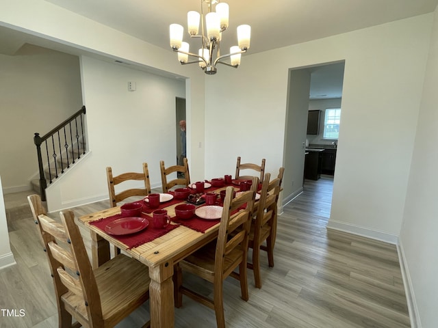 30 Junius Birch Trl, Franklinton, NC 27525 - dining area with light wood-style floors, a chandelier, baseboards, and stairs