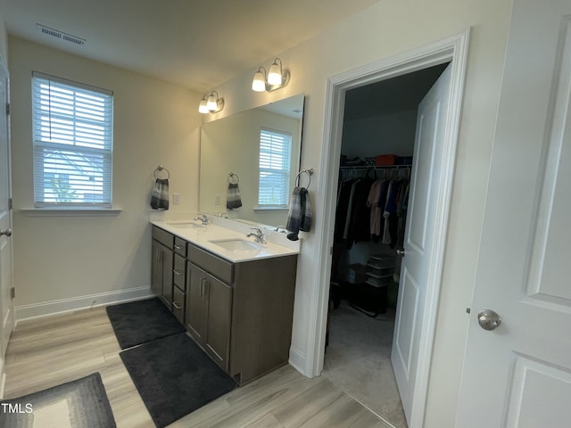 30 Junius Birch Trl, Franklinton, NC 27525 - bathroom featuring double vanity, wood finished floors, a spacious closet, and baseboards