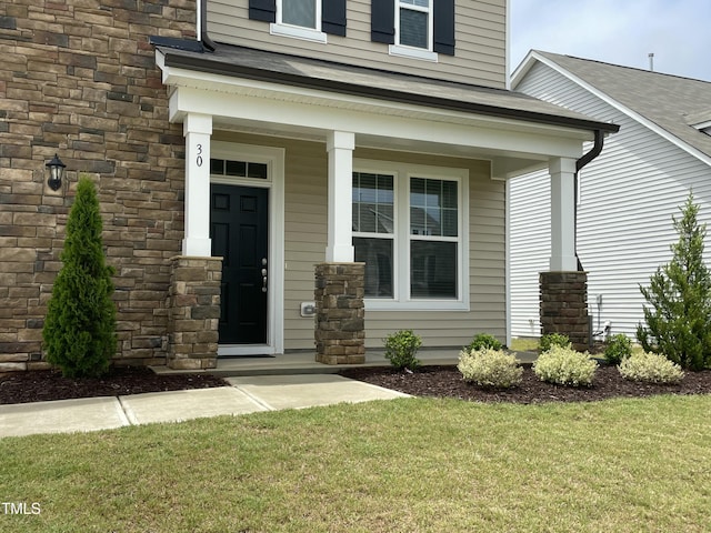 30 Junius Birch Trl, Franklinton, NC 27525 - view of exterior entry featuring covered porch, stone siding, and a yard