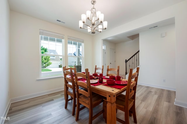 30 Junius Birch Trl, Franklinton, NC 27525 - dining area featuring light wood-style floors, a chandelier, and stairs