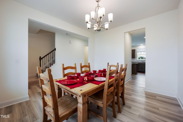 30 Junius Birch Trl, Franklinton, NC 27525 - dining room with light wood-type flooring, a chandelier, and stairs