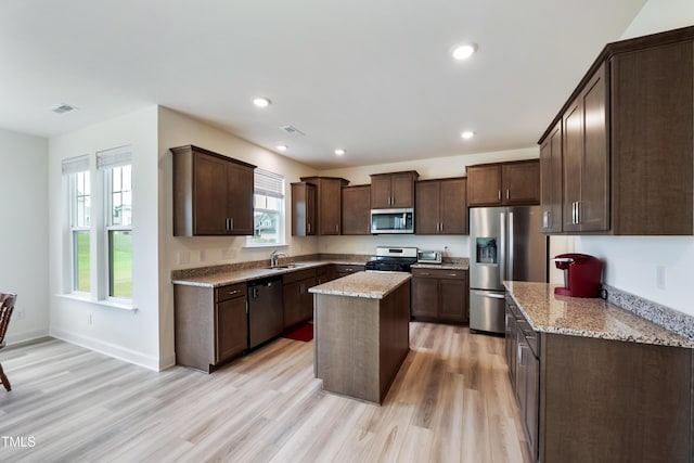 30 Junius Birch Trl, Franklinton, NC 27525 - kitchen with appliances with stainless steel finishes, light wood finished floors, dark brown cabinetry, light stone counters, and recessed lighting