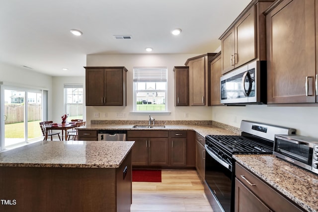 30 Junius Birch Trl, Franklinton, NC 27525 - kitchen with stainless steel appliances, healthy amount of natural light, light wood-style floors, light stone counters, and recessed lighting