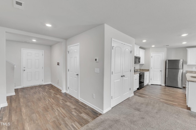 717 Little Patch St, Zebulon, NC 27597 - kitchen with stainless steel appliances, recessed lighting, wood finished floors, white cabinetry, and baseboards
