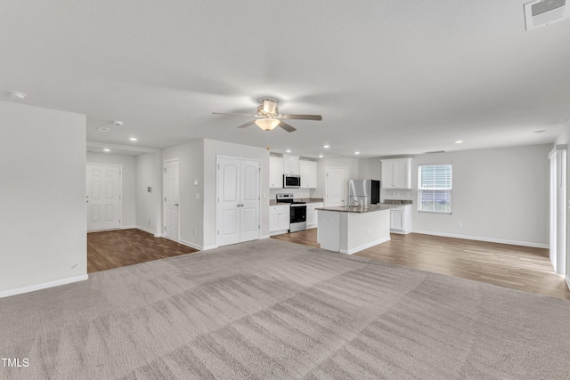 717 Little Patch St, Zebulon, NC 27597 - unfurnished living room featuring recessed lighting, baseboards, carpet, a ceiling fan, and wood finished floors