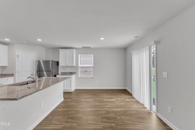 717 Little Patch St, Zebulon, NC 27597 - kitchen with a sink, freestanding refrigerator, wood finished floors, white cabinets, and recessed lighting