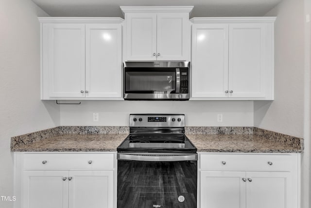 717 Little Patch St, Zebulon, NC 27597 - kitchen with stainless steel microwave, range with electric cooktop, white cabinetry, and light stone countertops