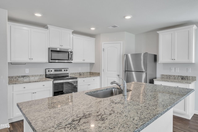 717 Little Patch St, Zebulon, NC 27597 - kitchen with stainless steel appliances, a sink, dark wood finished floors, white cabinets, and a kitchen island with sink