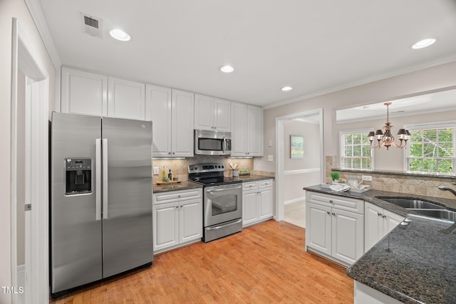313 Glen Echo Ln Unit J, Cary, NC 27518 - kitchen featuring appliances with stainless steel finishes, a sink, white cabinetry, tasteful backsplash, and crown molding