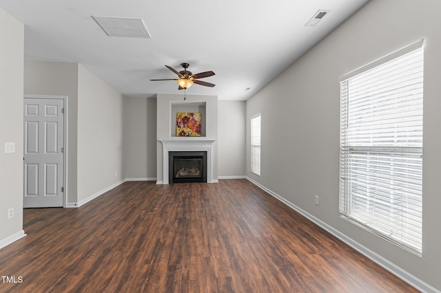 821 Stackhurst Way, Wake Forest, NC 27587 - unfurnished living room with dark wood-style flooring, a glass covered fireplace, baseboards, and a ceiling fan