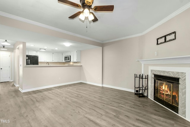 2233 Alpine Rd, Durham, NC 27707 - unfurnished living room featuring ornamental molding, baseboards, a ceiling fan, wood finished floors, and a fireplace