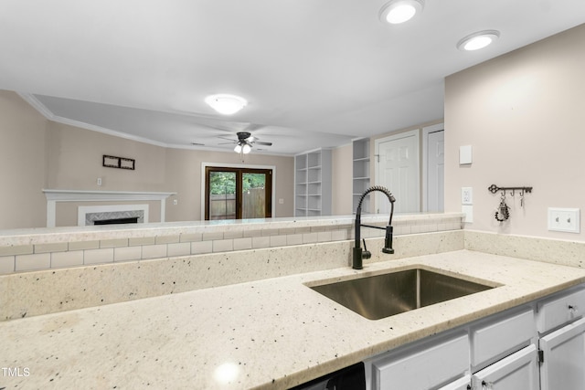2233 Alpine Rd, Durham, NC 27707 - kitchen featuring a sink, a ceiling fan, light stone countertops, a fireplace, and white cabinets