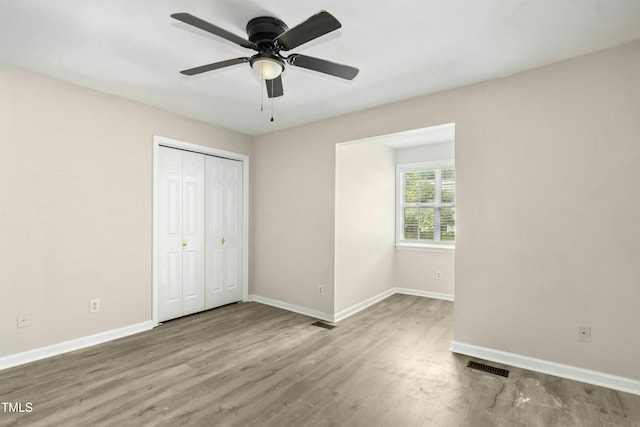 2233 Alpine Rd, Durham, NC 27707 - unfurnished bedroom featuring baseboards, wood finished floors, a closet, and a ceiling fan