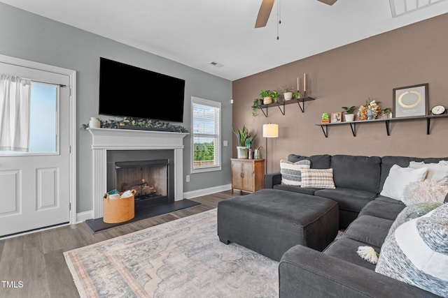 784 Cypress Rd, Cameron, NC 28326 - living room featuring a ceiling fan, wood finished floors, a fireplace with raised hearth, and baseboards