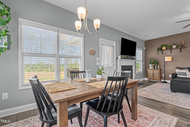 784 Cypress Rd, Cameron, NC 28326 - dining room featuring wood finished floors, a chandelier, a fireplace, and a ceiling fan