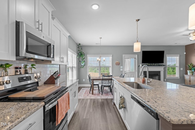784 Cypress Rd, Cameron, NC 28326 - kitchen featuring appliances with stainless steel finishes, a sink, dark wood-type flooring, white cabinets, and a fireplace