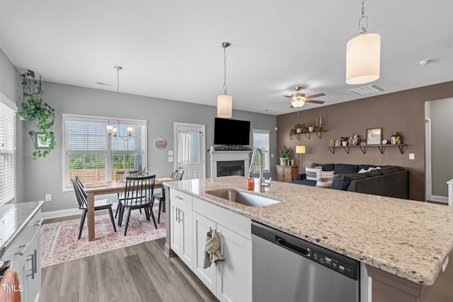 784 Cypress Rd, Cameron, NC 28326 - kitchen featuring stainless steel dishwasher, a sink, wood finished floors, a fireplace, and white cabinets