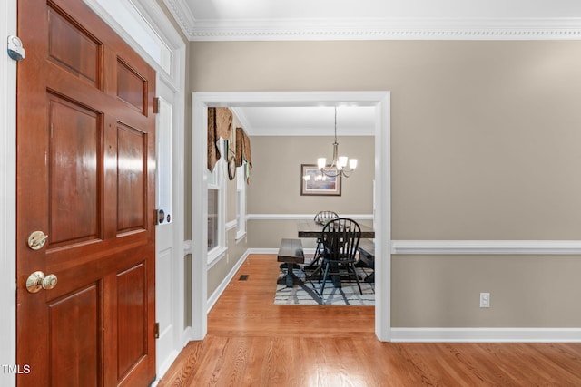 8536 Wolverton Fields Dr, Wake Forest, NC 27587 - foyer featuring crown molding, light wood-style flooring, a chandelier, and baseboards