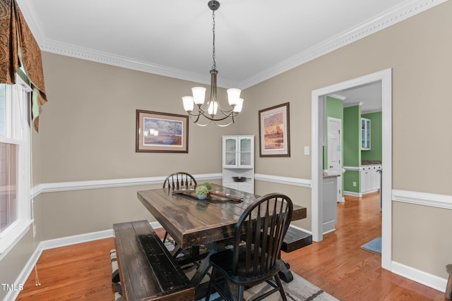 8536 Wolverton Fields Dr, Wake Forest, NC 27587 - dining room featuring light wood finished floors, ornamental molding, a chandelier, and baseboards