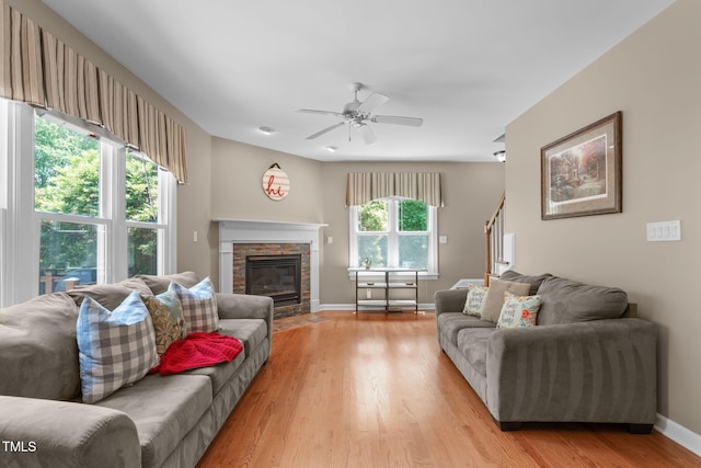 8536 Wolverton Fields Dr, Wake Forest, NC 27587 - living room with light wood finished floors, a fireplace, a ceiling fan, baseboards, and stairway