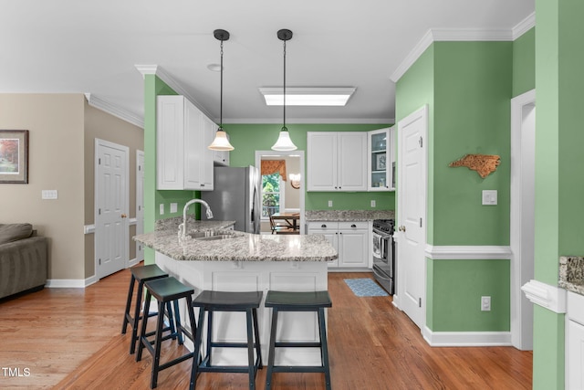 8536 Wolverton Fields Dr, Wake Forest, NC 27587 - kitchen featuring stainless steel appliances, a sink, a peninsula, white cabinets, and a breakfast bar
