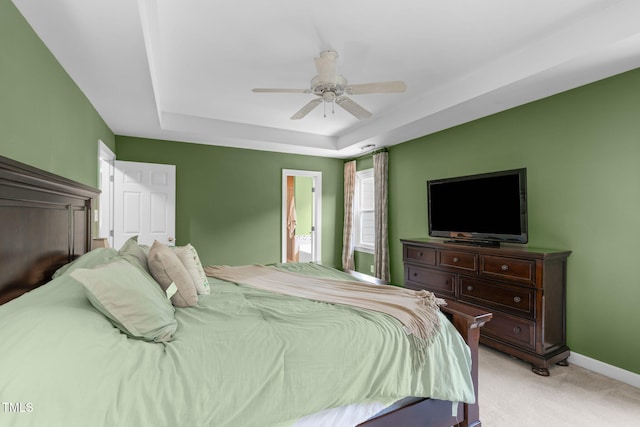 8536 Wolverton Fields Dr, Wake Forest, NC 27587 - bedroom featuring a tray ceiling, light colored carpet, baseboards, ceiling fan, and ensuite bathroom