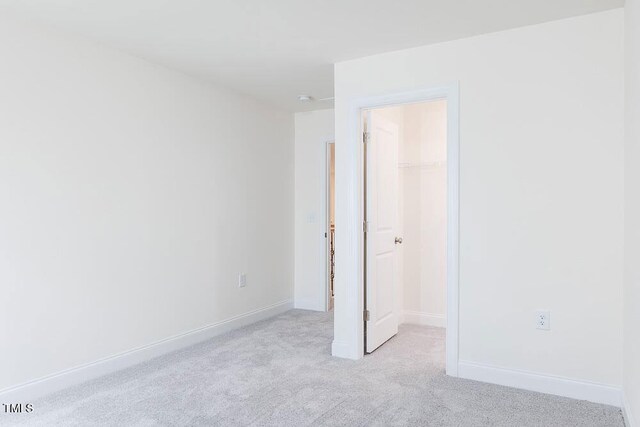 1128 Sun Springs Rd, Wake Forest, NC 27587 - unfurnished bedroom with a spacious closet, light colored carpet, a closet, and baseboards