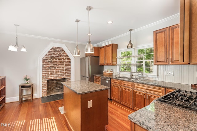 411 E Green St, Franklinton, NC 27525 - kitchen featuring stainless steel appliances, a sink, brown cabinets, light wood finished floors, and a kitchen island