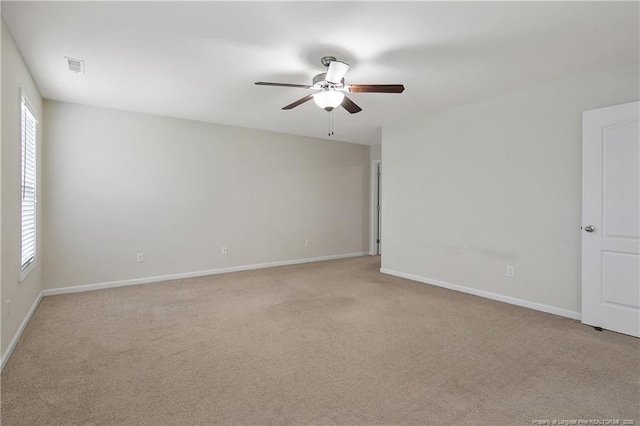 unfurnished room featuring plenty of natural light, a ceiling fan, light carpet, and baseboards