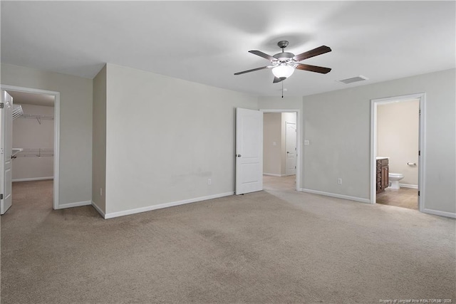 unfurnished bedroom featuring a spacious closet, carpet, baseboards, and a closet