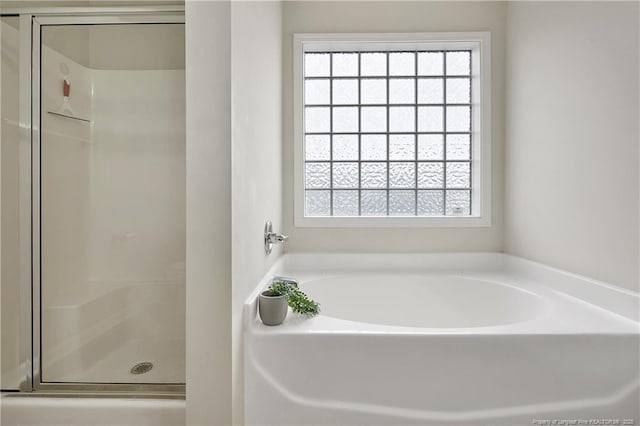 bathroom with a garden tub and a shower stall