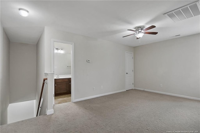 empty room with a ceiling fan, light colored carpet, and baseboards