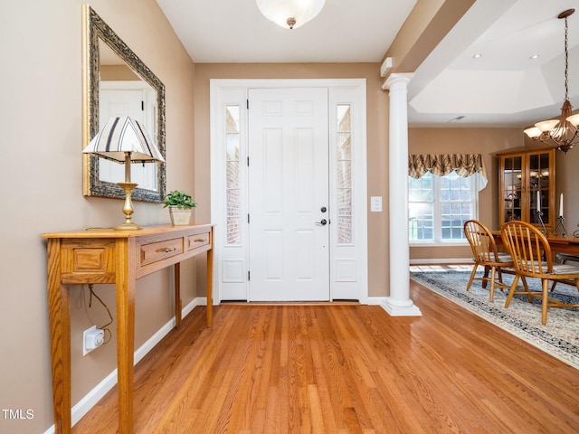 8917 Thompson Mill Rd, Wake Forest, NC 27587 - entrance foyer with ornate columns, light wood-style flooring, baseboards, and a chandelier