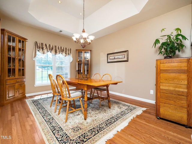 8917 Thompson Mill Rd, Wake Forest, NC 27587 - dining room with light wood-style flooring, a chandelier, a raised ceiling, and baseboards