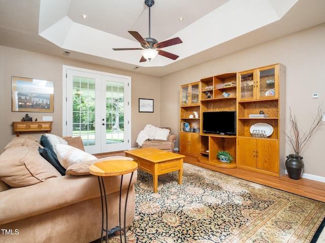 8917 Thompson Mill Rd, Wake Forest, NC 27587 - living room with french doors, a tray ceiling, wood finished floors, and a ceiling fan