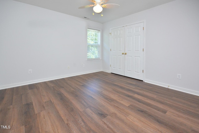 1056 Evening Shade Ave, Rolesville, NC 27571 - unfurnished bedroom with dark wood finished floors, baseboards, a ceiling fan, and a closet