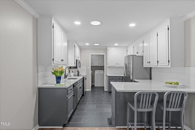 3 Haggis Ct, Durham, NC 27705 - kitchen featuring washer / clothes dryer, freestanding refrigerator, a sink, a peninsula, and white cabinets