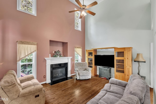 1325 Red Brick Rd, Garner, NC 27529 - living room featuring a high ceiling, a ceiling fan, wood finished floors, a fireplace with flush hearth, and plenty of natural light