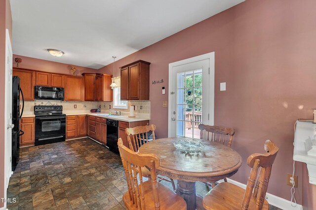1325 Red Brick Rd, Garner, NC 27529 - kitchen with black appliances, a sink, stone finish flooring, decorative backsplash, and light countertops