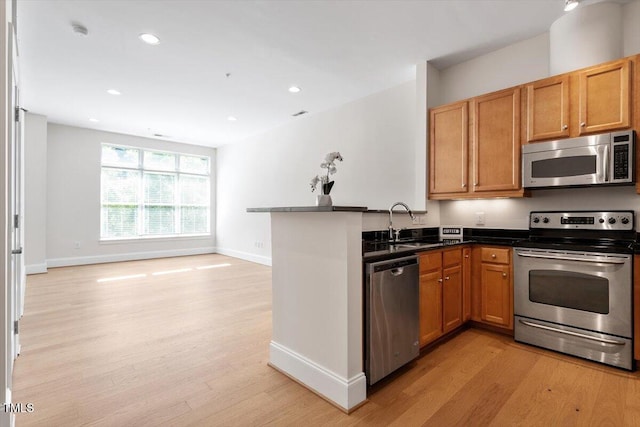 317 W Morgan St Unit 320, Raleigh, NC 27601 - kitchen featuring appliances with stainless steel finishes, light wood-style flooring, a sink, baseboards, and recessed lighting