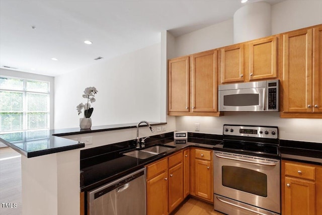 317 W Morgan St Unit 320, Raleigh, NC 27601 - kitchen with stainless steel appliances, a sink, a peninsula, light wood finished floors, and recessed lighting