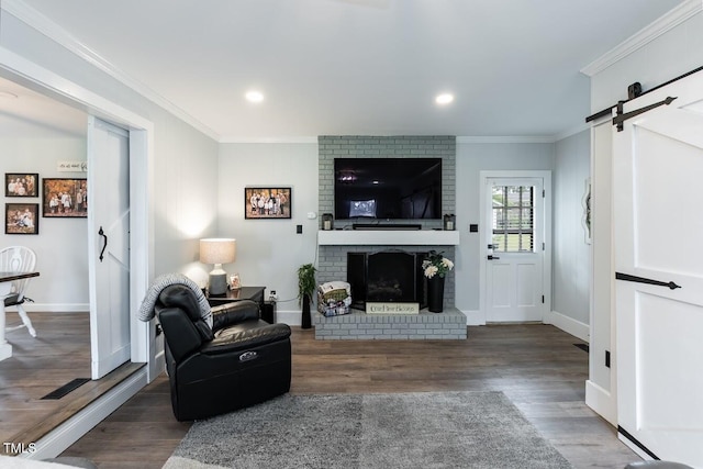 103 Midway Ln, Roanoke Rapids, NC 27870 - living area featuring a barn door, ornamental molding, a fireplace, wood finished floors, and recessed lighting