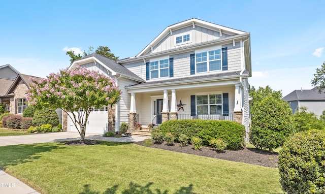 633 Copper Beech Ln, Wake Forest, NC 27587 - craftsman-style home with driveway, board and batten siding, covered porch, a front lawn, and an attached garage