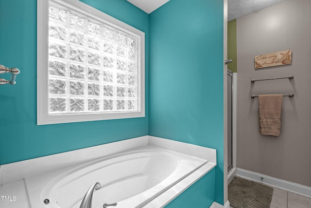 1016 Luminary Ln, Willow Springs, NC 27592 - bathroom featuring a garden tub, tile patterned flooring, a stall shower, and baseboards