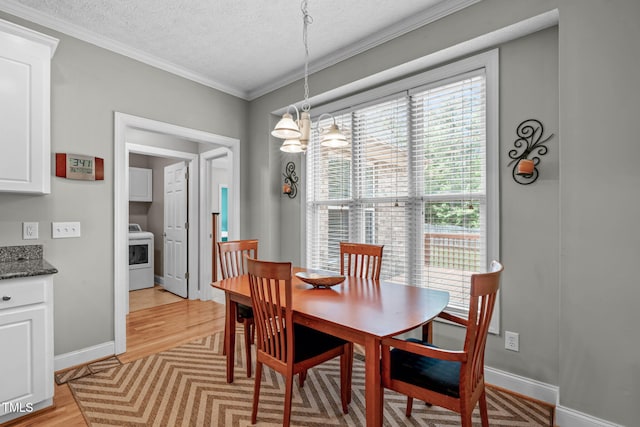 1016 Luminary Ln, Willow Springs, NC 27592 - dining area featuring washer / clothes dryer, a chandelier, light wood-style floors, a textured ceiling, and crown molding