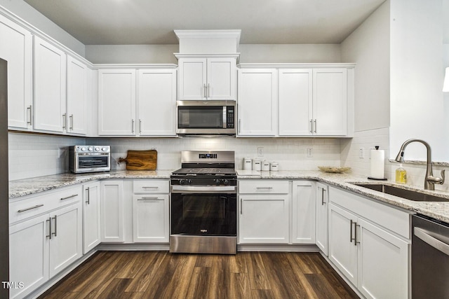 433 Parker Station Ave, Fuquay Varina, NC 27526 - kitchen featuring stainless steel appliances, a sink, white cabinets, tasteful backsplash, and dark wood-style flooring