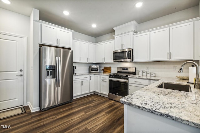 433 Parker Station Ave, Fuquay Varina, NC 27526 - kitchen featuring appliances with stainless steel finishes, a sink, dark wood-style floors, white cabinets, and recessed lighting